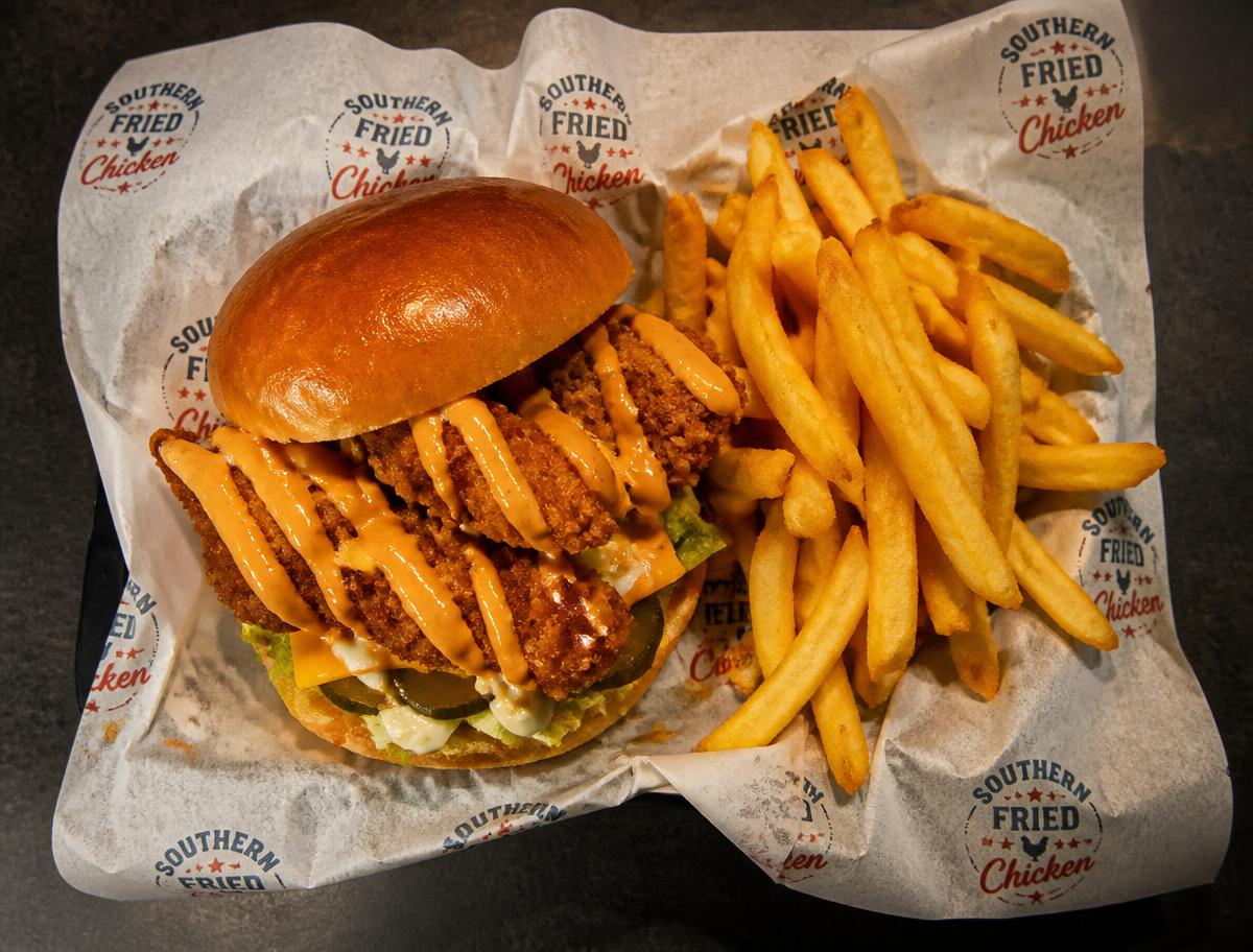 Strip burger with crispy chicken and a portion of golden chips